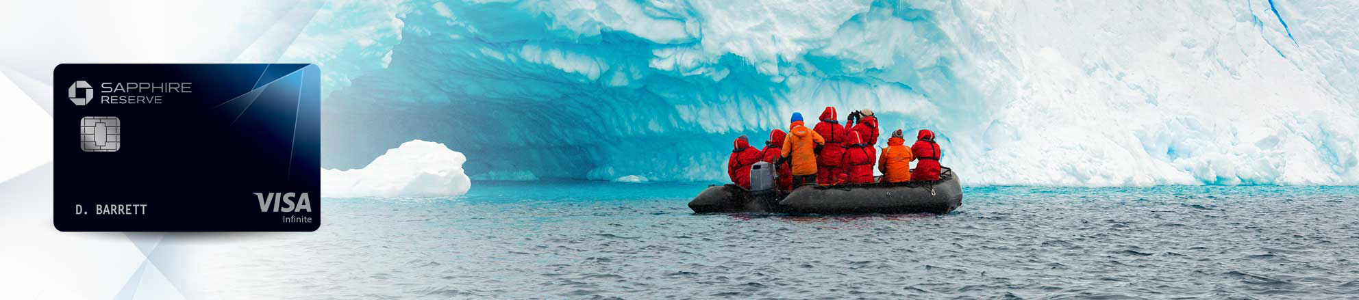 Chase Sapphire Reserve(Registered Trademark) credit card to the left of a group of people on a boat tour in the ocean near a glacier